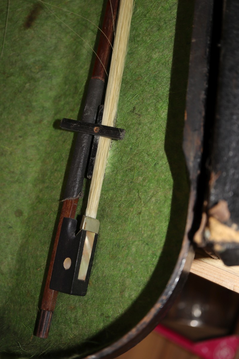 An early 20th century Saxon violin cased with bow and a cased banjo